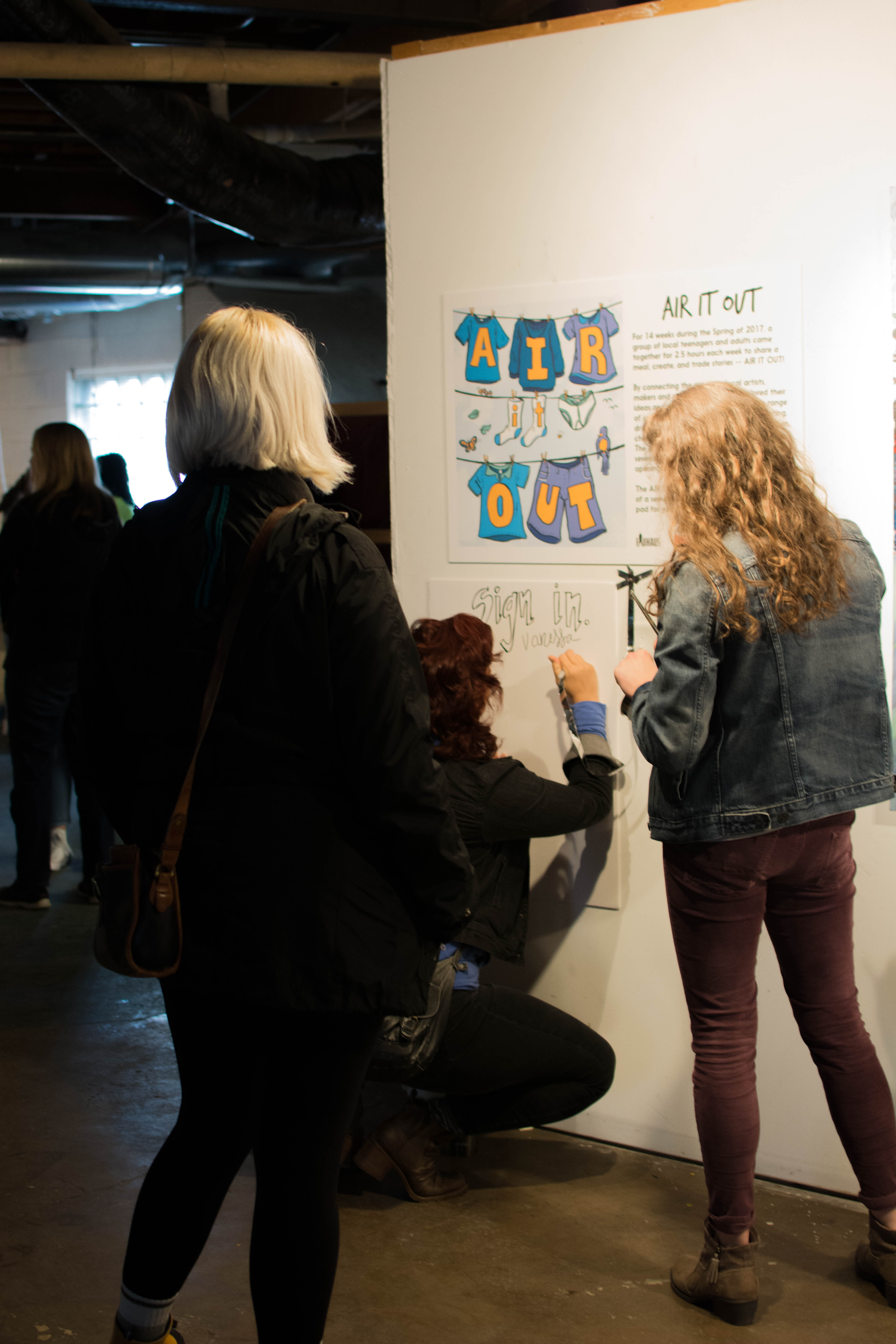 picture of people signing in at the Air It Out exhibition