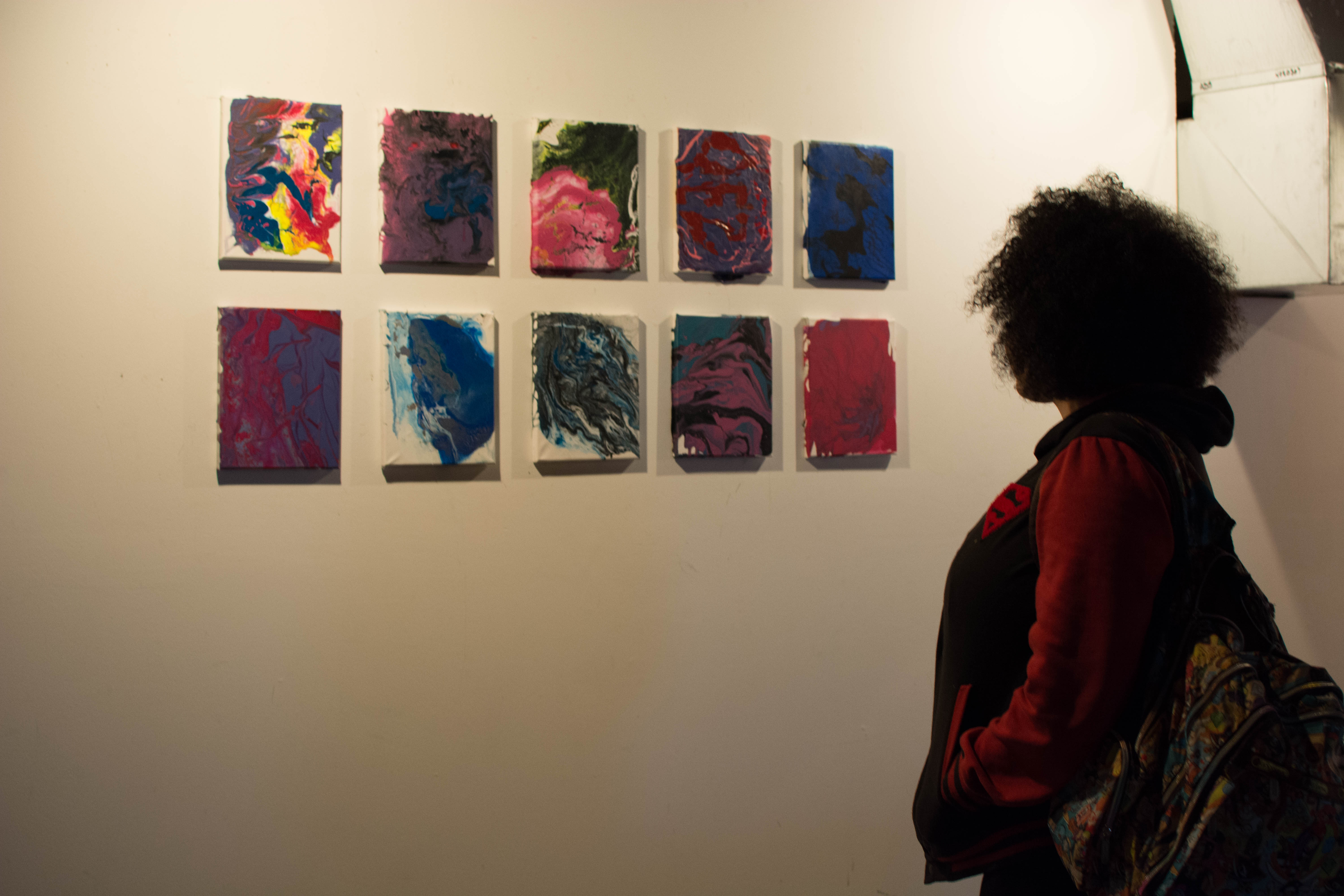 picture of teen viewing drip paintings at Air It Out teen art exhibition